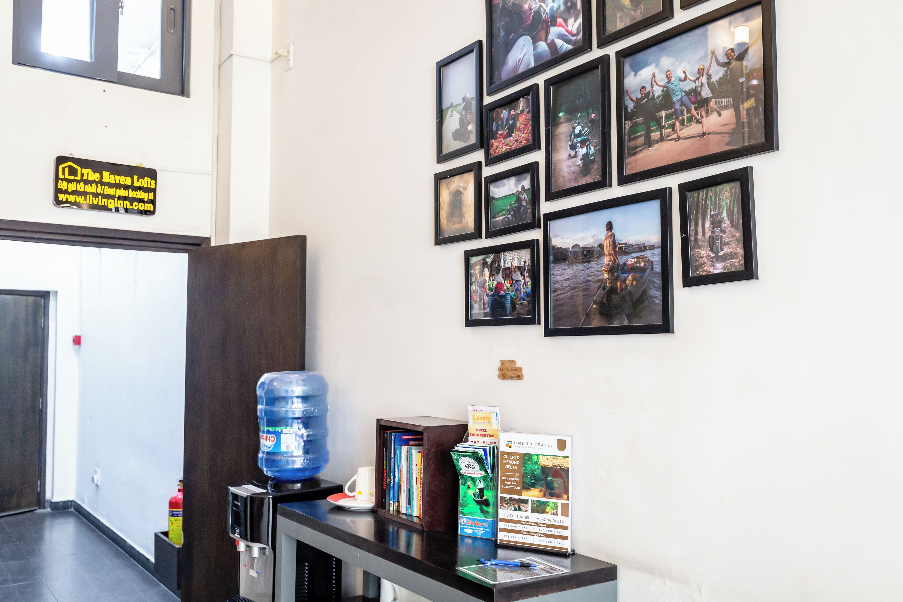 A reception area with a water dispenser, a coffee machine, a magazine rack, and a sign for The Haven Lofts.