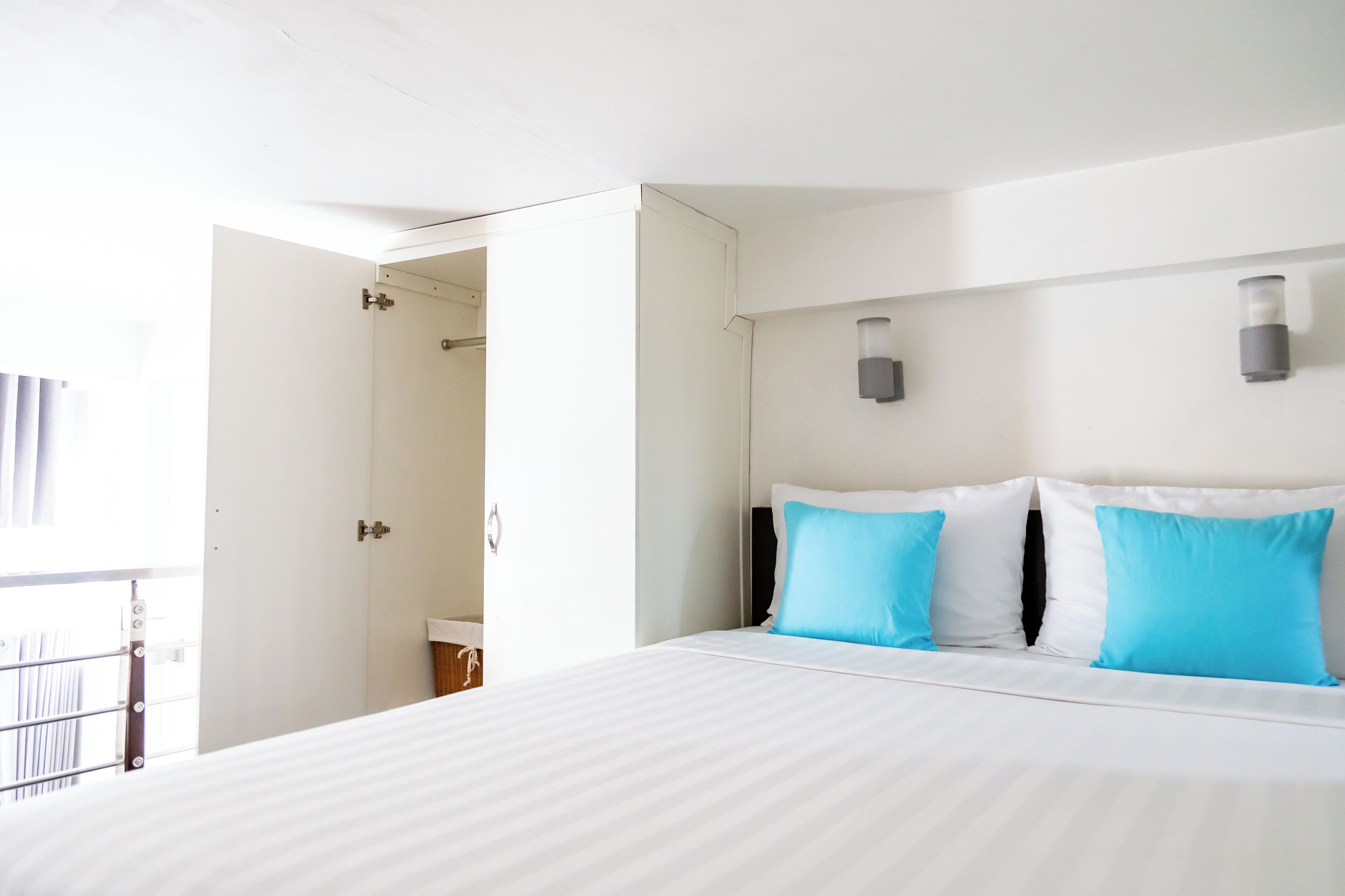 A hotel room with a large bed, two wall-mounted lights, and a door leading to a bathroom.