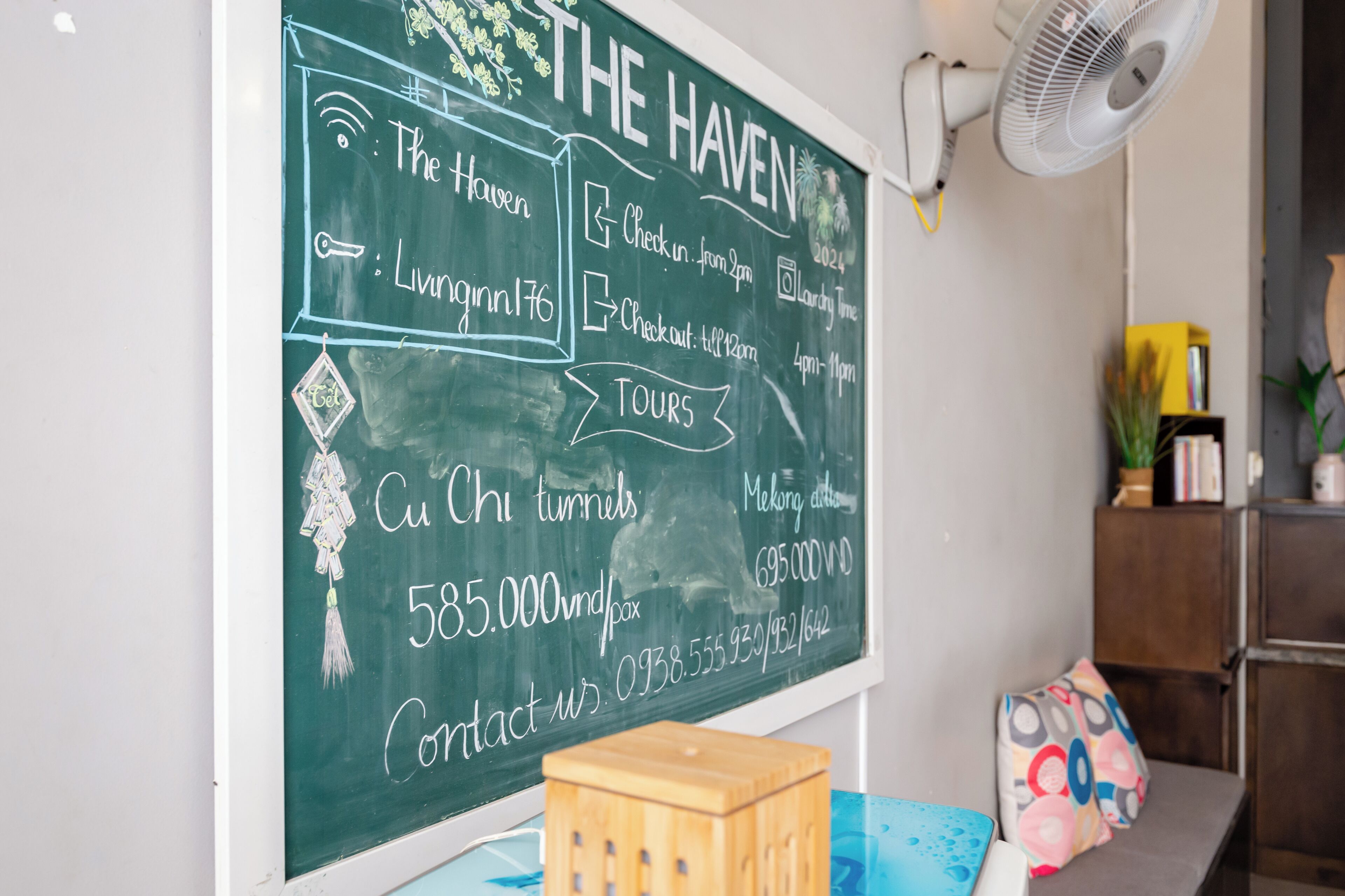 A chalkboard with hotel information, including check-in and checkout times, tours, and contact details.