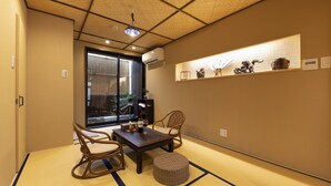 A traditional Japanese room with tatami flooring, a low table, two chairs, and a small shelf with decorative items. - Shirakabanoyado-Uchikyuhoji (Osaka)