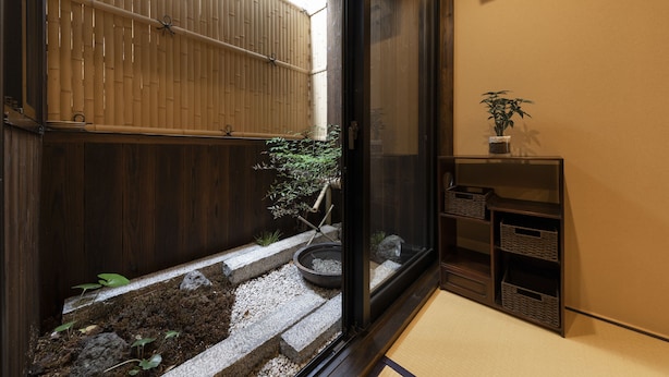 A traditional Japanese room with tatami flooring, a shoji screen, a small garden with stepping stones, and a shelf with baskets. - Shirakabanoyado-Uchikyuhoji (Osaka)