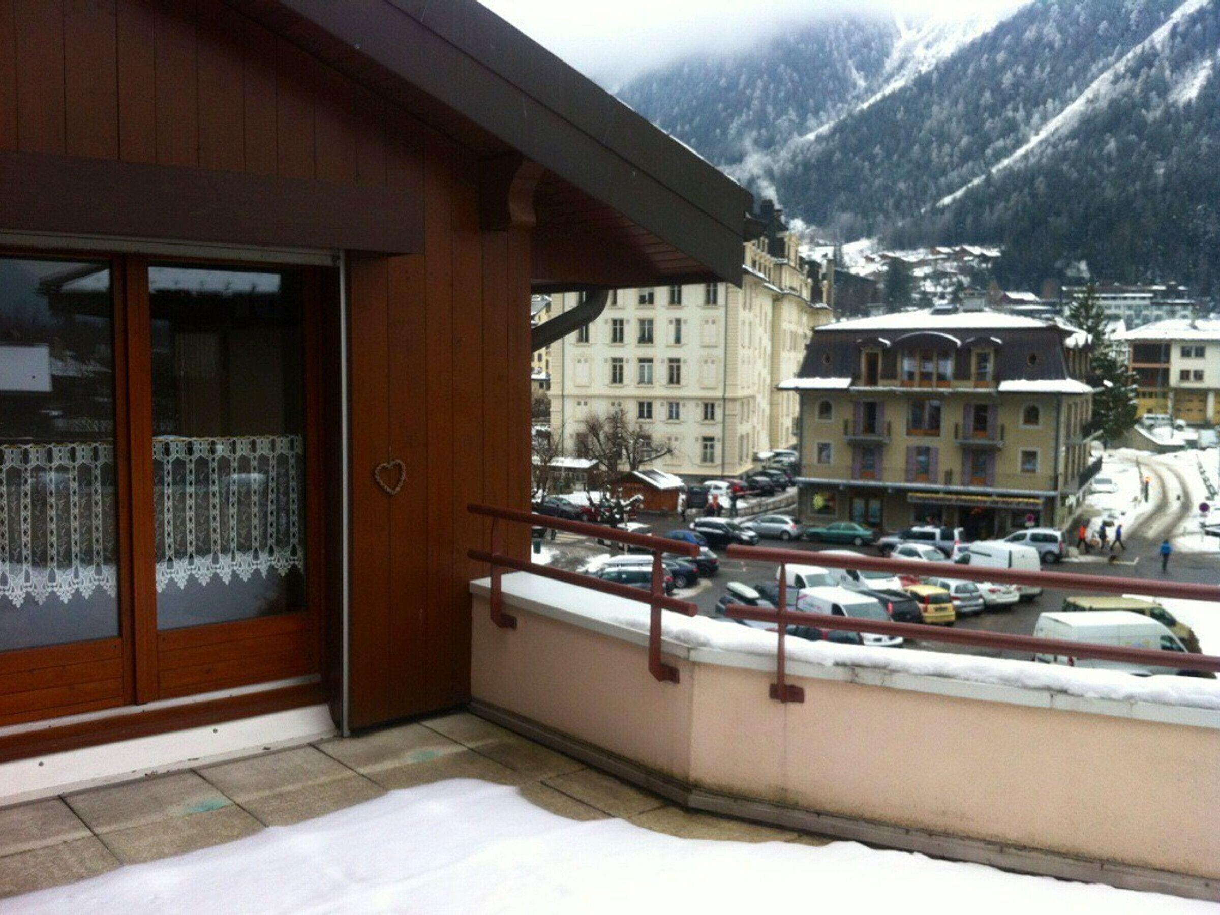 A balcony with a view of a town and mountains.