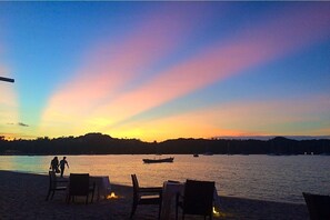 A sunset view from a beachside restaurant with tables and chairs facing the water. - Kirati Beach Resort (Koh Samui)