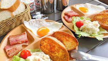 A breakfast tray with eggs, bacon, toast, and salad.