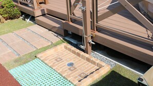 A wooden deck with a metal railing, a small pool area with a drain, and a wooden walkway. - Ufufu Village - Glamping (Izu)