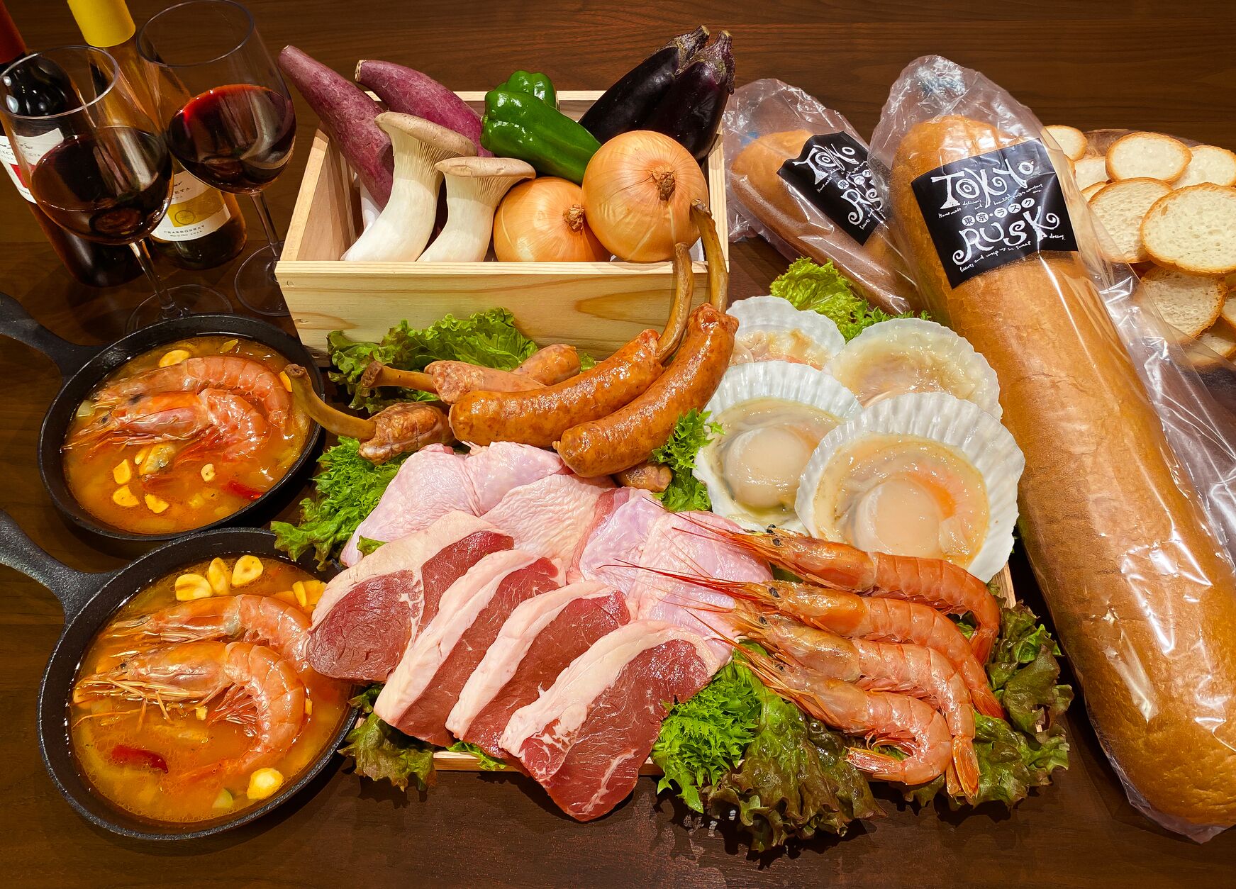 A variety of food items including seafood, bread, and vegetables on a wooden table.