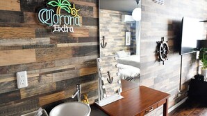 A modern bathroom with a wooden wall, a large mirror, a sink, and a vanity table. - Marine-Q (Inami)