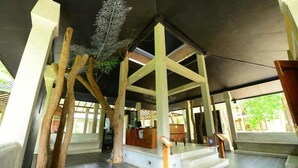 Un espacio interior con techo alto, vigas de madera y una recepción.