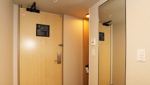 A hallway with wooden doors, a mirror, and a light switch on the wall.