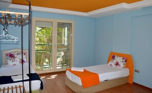 A bedroom with two beds, a wooden floor, and a large window with a view of trees. - Zen House (Kusadasi)