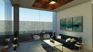 A modern living room with a sofa, two armchairs, a coffee table, and a painting on the wall. - Daun Residence Bandung (Bandung)