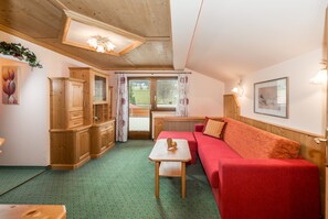 Leilighet – deluxe | Oppholdsområde | En 32-tommers Flatskjerm-TV med Parabol-TV samt TV