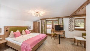 A bedroom with a bed, a desk with a television, and a window. - Alpenecho (Ramsau am Dachstein)