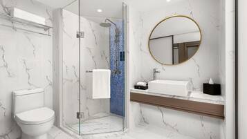 A modern bathroom with a glass-enclosed shower, a white toilet, a marble-tiled floor, and a wooden vanity with a sink and mirror.