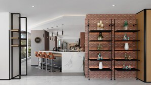 Una cocina moderna con encimera de mármol, pared de ladrillo decorativa y una zona de bar con taburetes.
