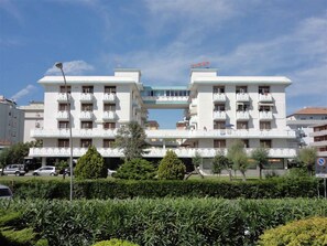 Un hôtel de taille moyenne doté d’un atrium central, de nombreux balcons et d’un espace de stationnement situé à l’avant.
