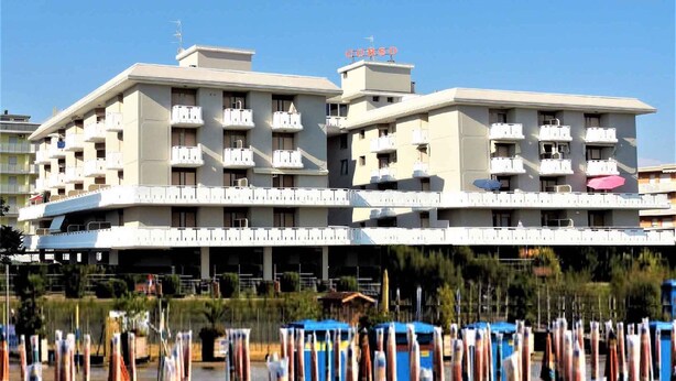 Een hotel met meerdere verdiepingen, balkons en airconditioningsunits.