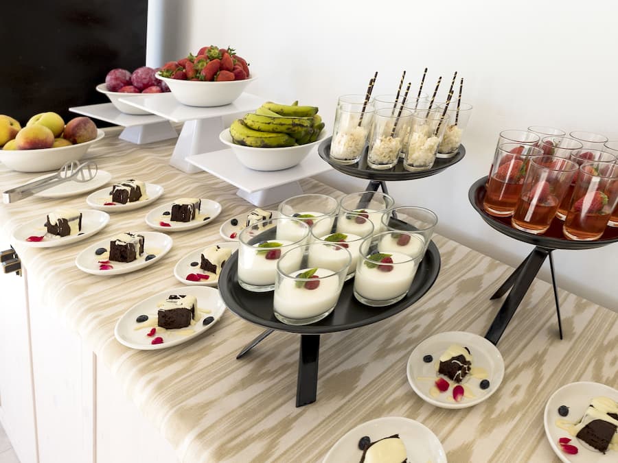 Una mesa de buffet con diversos postres y frutas.