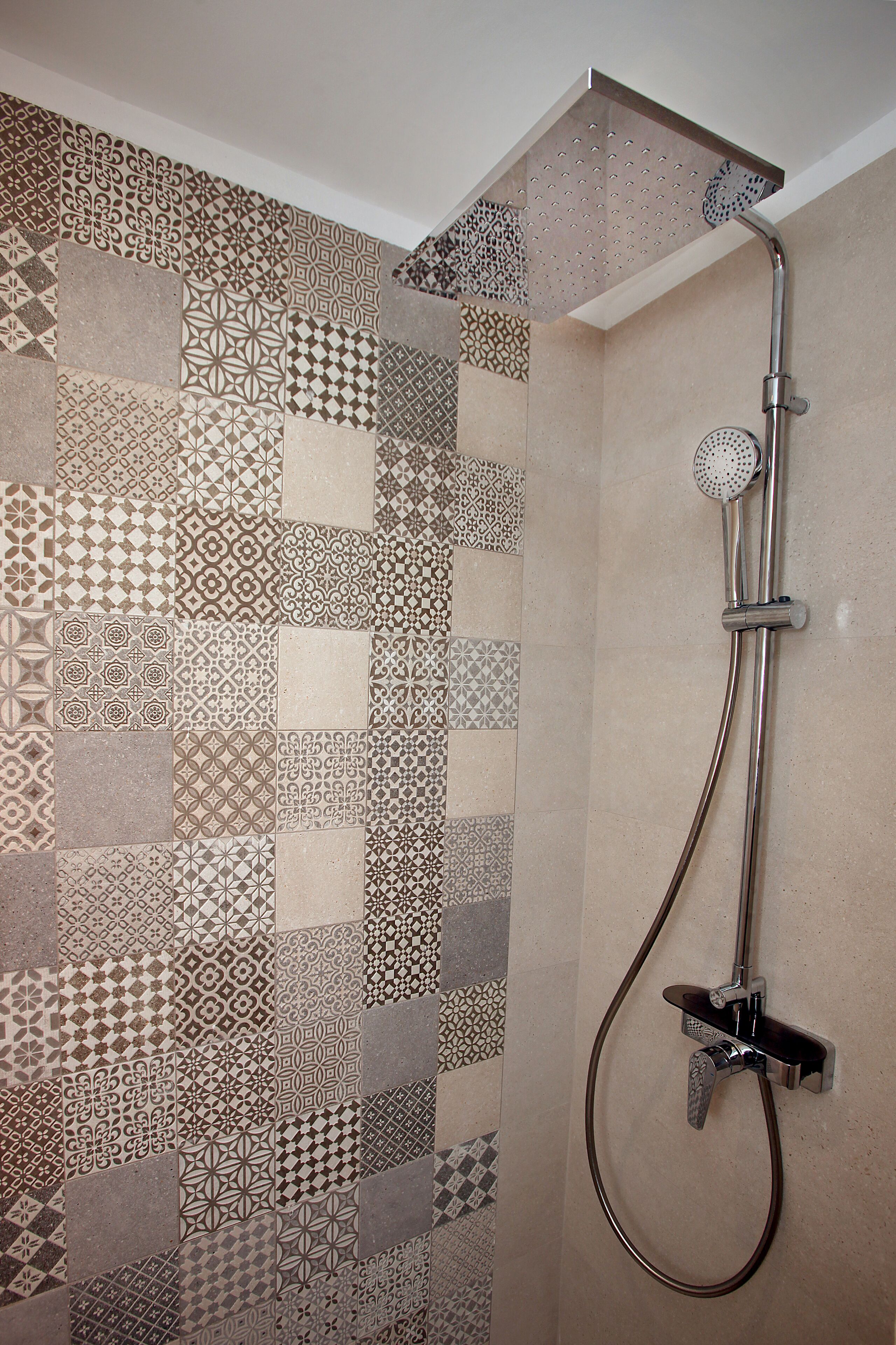 A shower with a modern design, featuring a rain shower head and a handheld shower attachment.