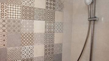 A shower with a modern design, featuring a rain shower head and a handheld shower attachment.