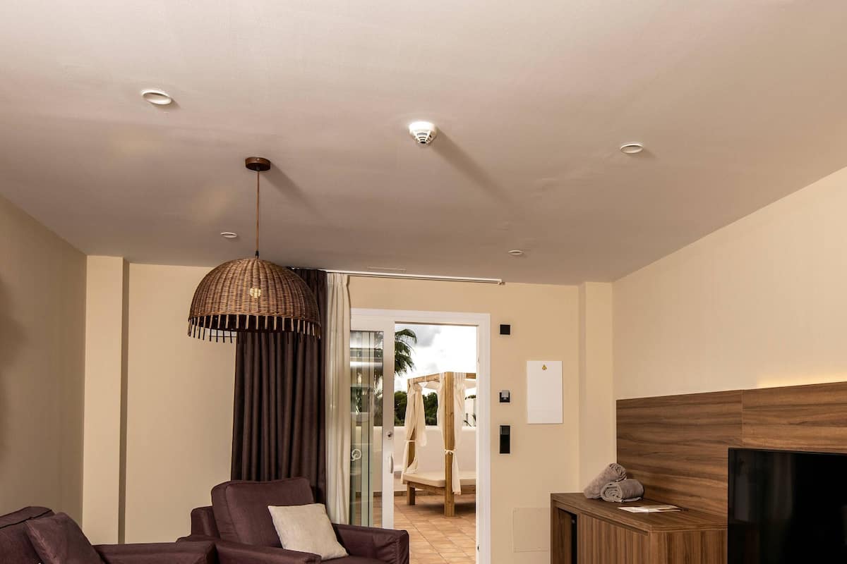 A modern living room with a sectional sofa, a TV, and a wooden entertainment unit.