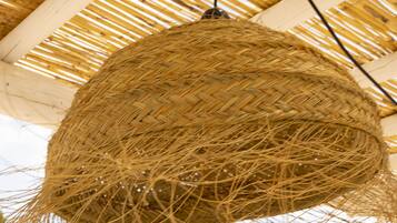 A woven hanging light fixture with a natural fiber design.