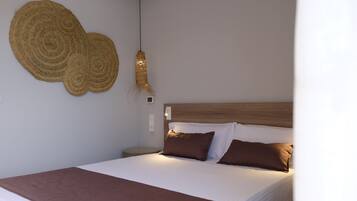 Un lit bien fait, avec une couverture marron et des oreillers, une tête de lit en bois et un objet décoratif fixé au mur.