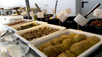 Een buffet met diverse gerechten en bestek.