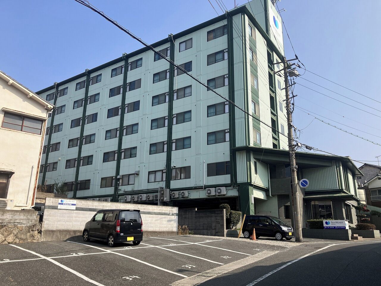 A multi-story building with a parking lot in front.