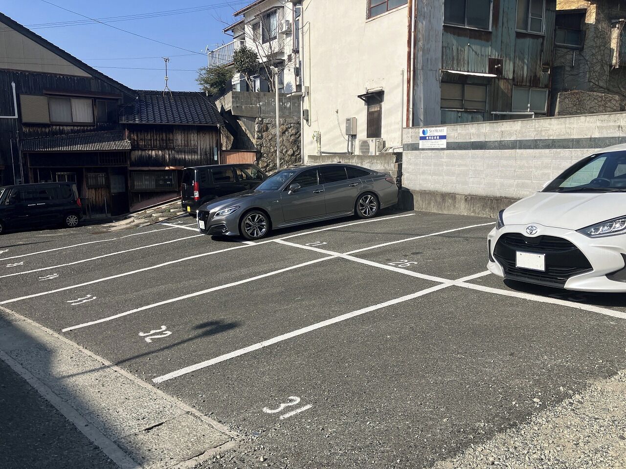 A parking lot with marked spaces and a building in the background.