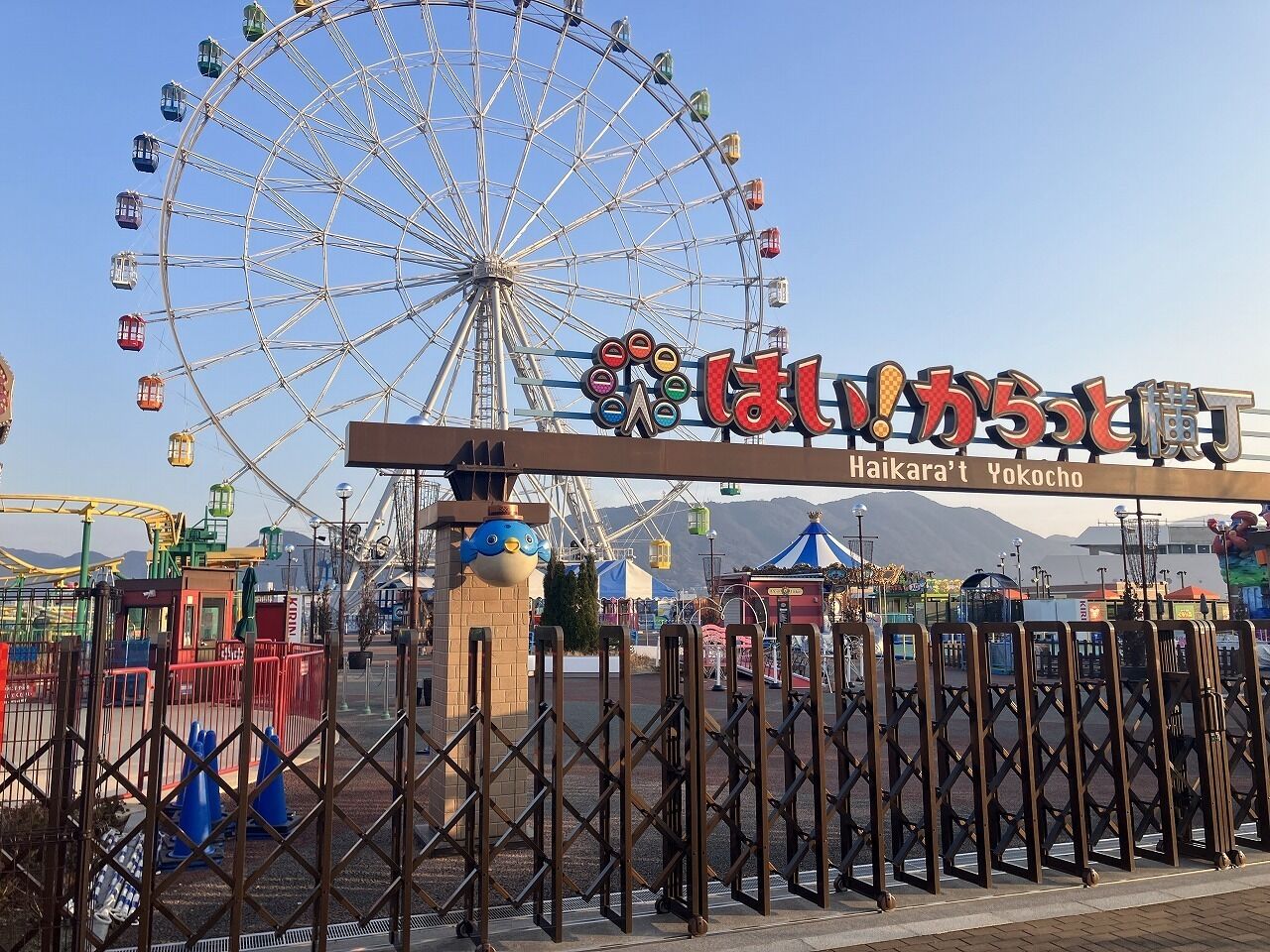 Une grande roue et une enseigne avec des caractères japonais.