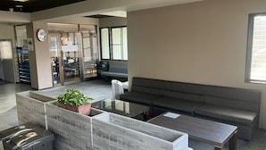 Een moderne zithoek met een bank, een bijzettafeltje en een prullenbak.