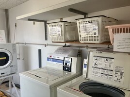 Un área de lavandería con lavadora, secadora y panel de control.