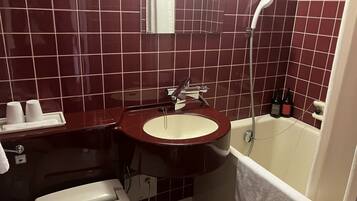 Un baño con lavamanos, inodoro y bañera.