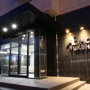 A modern building entrance with glass doors and a sign that reads 'ABLO YUKUH'.