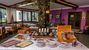 A breakfast buffet with various food items and a Christmas tree in a room with purple walls and large windows.