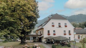 A two-story building with a garden patio and outdoor seating area.