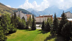 Ein Hotelkomplex mit mehreren Gebäuden, umgeben von Bäumen und Bergen im Hintergrund.