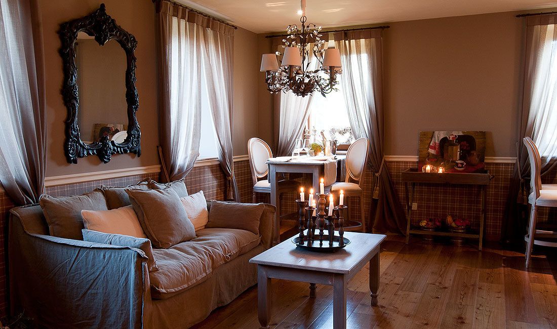 Una sala de estar acogedora con un sofá, una mesa con velas y una araña.