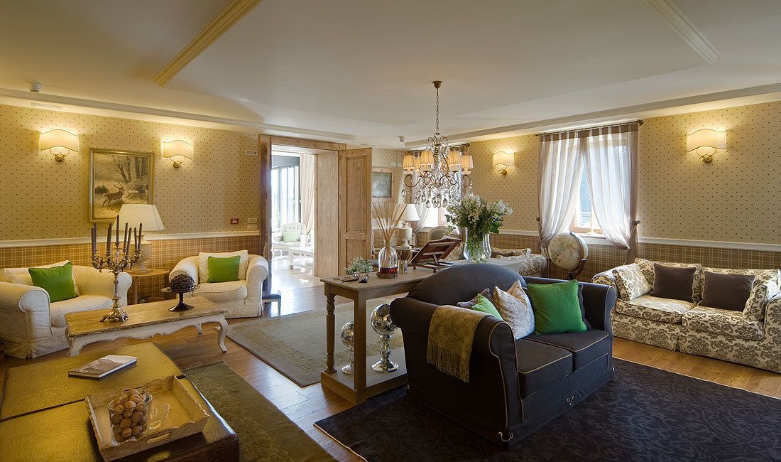A spacious living room with a fireplace, two sofas, a coffee table, and a chandelier.