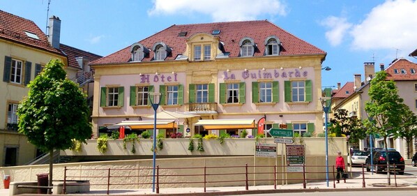 A hotel with a red-tiled roof, green shutters, and a sign reading "Hotel La Guimbarde." - Hotel La Guimbarde (Morteau)