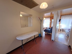 A room with a bed, a chair, a table, a mirror, and a floor lamp. - Apartment 8 guests, near slopes, pets allowed (Les Deux Alpes)