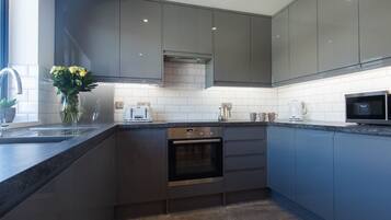 Departamento Deluxe | Cocina privada | Refrigerador con congelador, microondas, horno y parrilla de estufa
