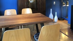 A dining area with a wooden table, chairs, a lamp, and a painting on the wall. - Apartment "Am Berg" in Fischbachau, Birkenstein (Fischbachau)
