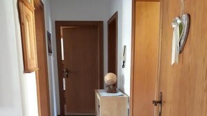 A hallway with wooden doors, a small table with a globe, and a door with a shoe rack. - Landhaus St. Georg (Sankt Martin am Tennengebirge)