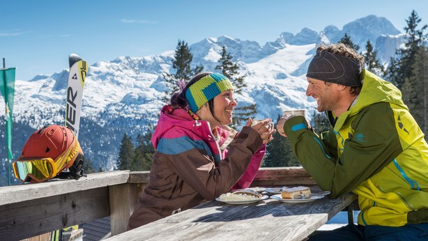 A wooden picnic table with a mountain view in the background. - Landhaus St. Georg (Sankt Martin am Tennengebirge)