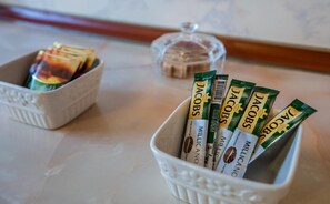 A white ceramic bowl filled with coffee pods labeled 'Jacobs' and 'Millican'. - Vivid Vera Apartments (Tbilisi)