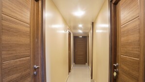 Een gang met houten deuren aan beide kanten, die leidt naar een ruimte met de tekst 'ROOM NO 302'.