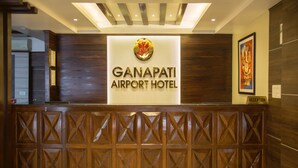 Een receptiebalie met een bord waarop staat: GANAPATI AIRPORT HOTEL.