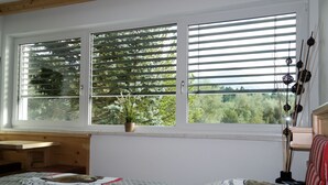 A bedroom with a bed, a desk, and a window with blinds. - Tischlmuehle Appartements & mehr (Mitterberg-Sankt Martin)